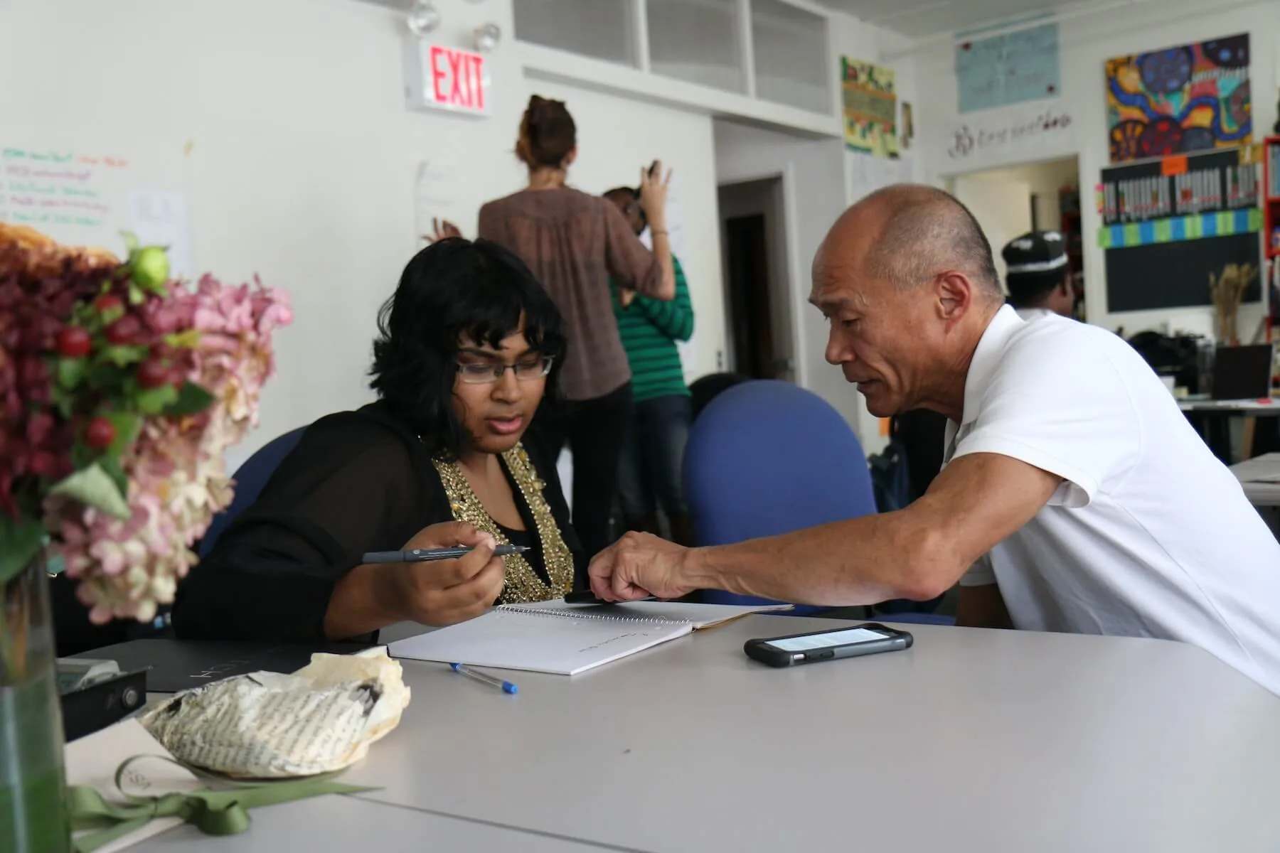 two people sitting at desk looking at notebook nurse mentorship