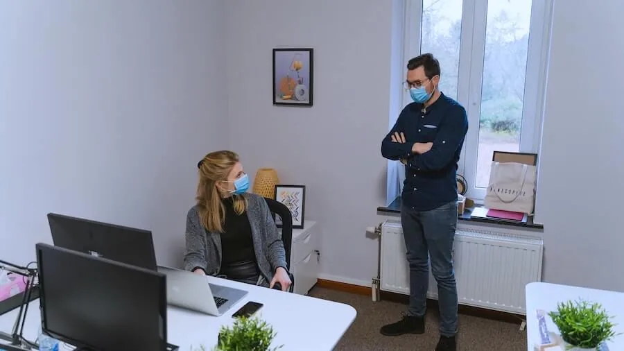 man and woman with masks on in office in front of computer health policy nurse informatics